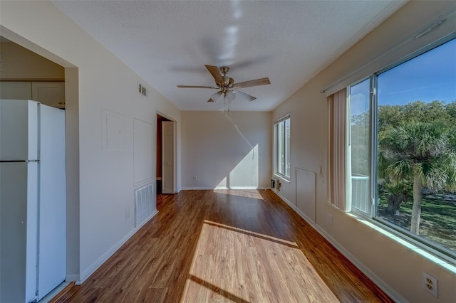 interior space featuring ceiling fan, hardwood / wood-style floors, and a textured ceiling