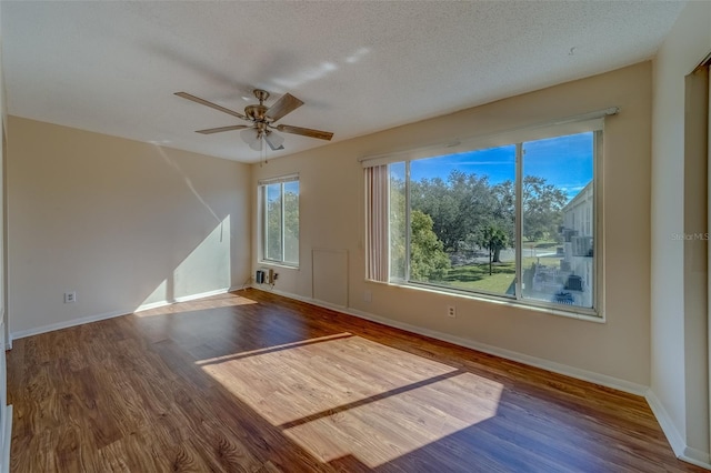 spare room with ceiling fan, dark hardwood / wood-style floors, and a textured ceiling