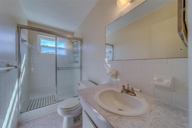 bathroom featuring tile walls, an enclosed shower, vanity, and toilet