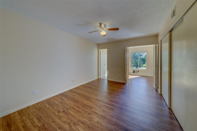 spare room featuring hardwood / wood-style floors, a textured ceiling, and ceiling fan