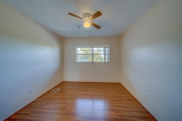 empty room with wood-type flooring, ceiling fan, and a textured ceiling