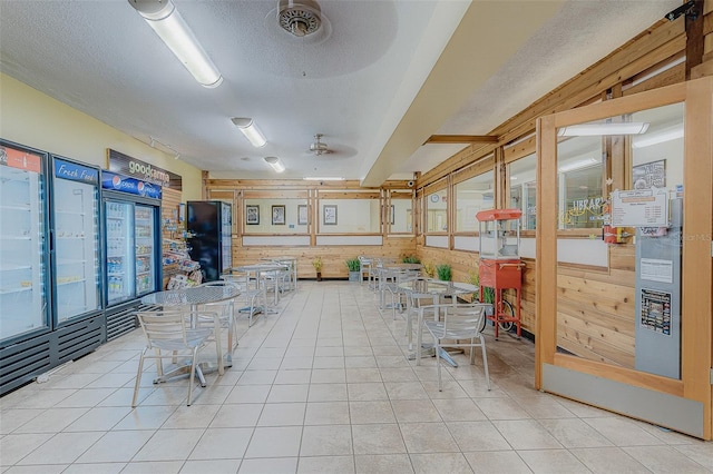 unfurnished dining area featuring light tile patterned floors, a textured ceiling, and ceiling fan