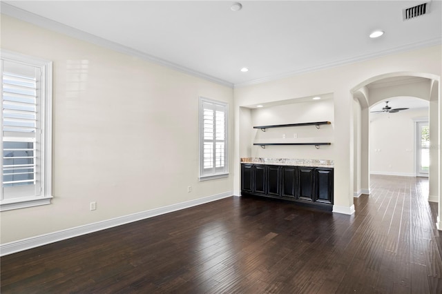 unfurnished living room featuring ornamental molding, dark wood-type flooring, and ceiling fan