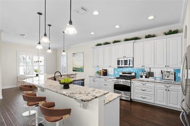 kitchen featuring hanging light fixtures, white cabinetry, and appliances with stainless steel finishes