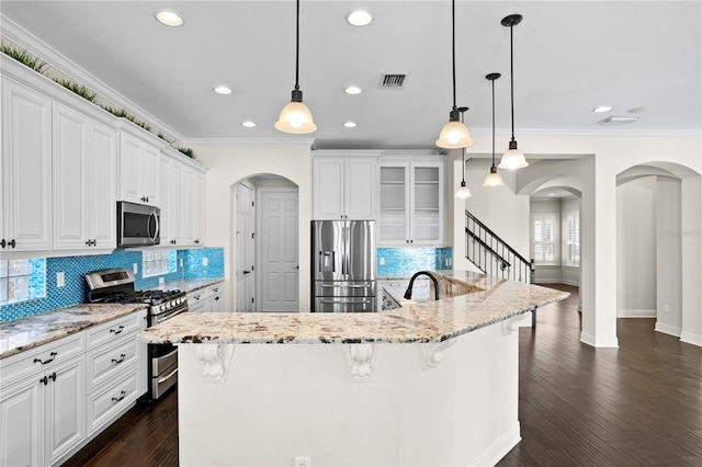 kitchen with hanging light fixtures, a breakfast bar area, white cabinets, and appliances with stainless steel finishes