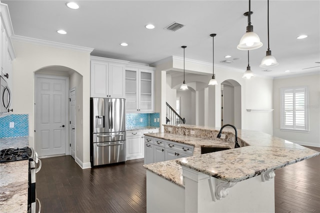 kitchen with pendant lighting, white cabinetry, appliances with stainless steel finishes, and a spacious island