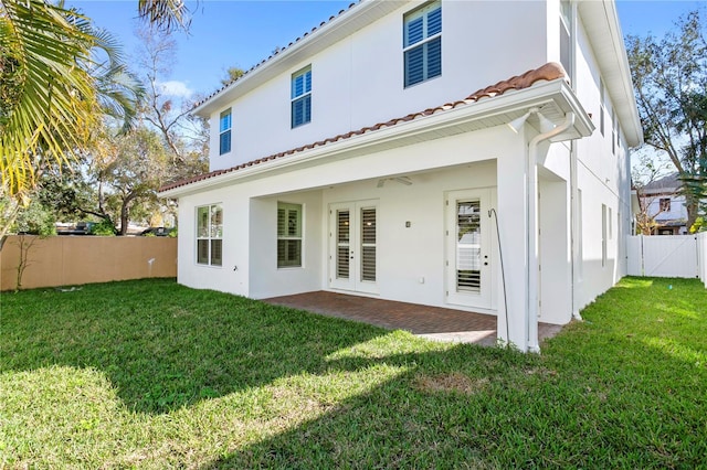 rear view of house with a patio and a lawn