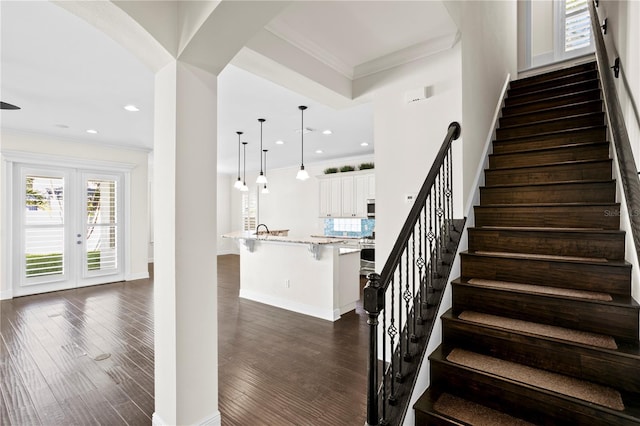 stairs featuring ornamental molding, wood-type flooring, and french doors