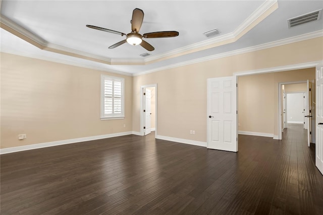 spare room featuring a raised ceiling, ornamental molding, and dark hardwood / wood-style floors