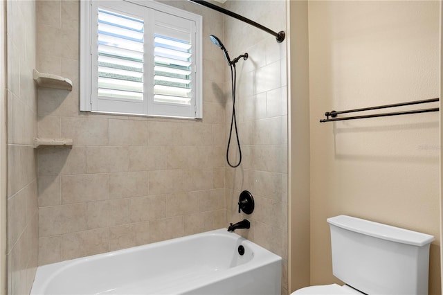 bathroom with tiled shower / bath combo and toilet