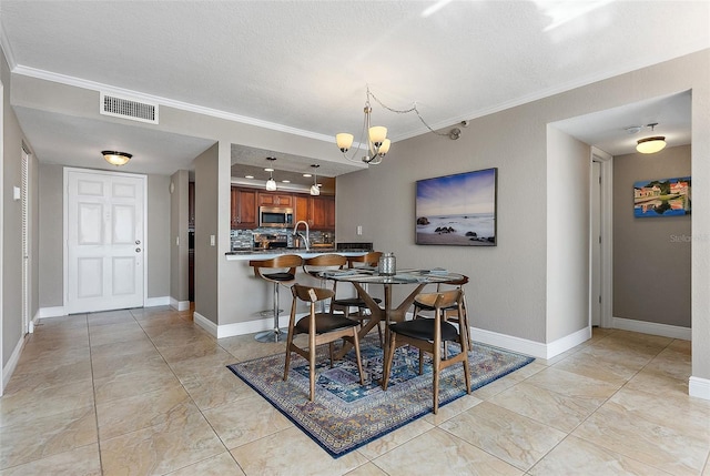 dining room featuring crown molding, sink, and a notable chandelier