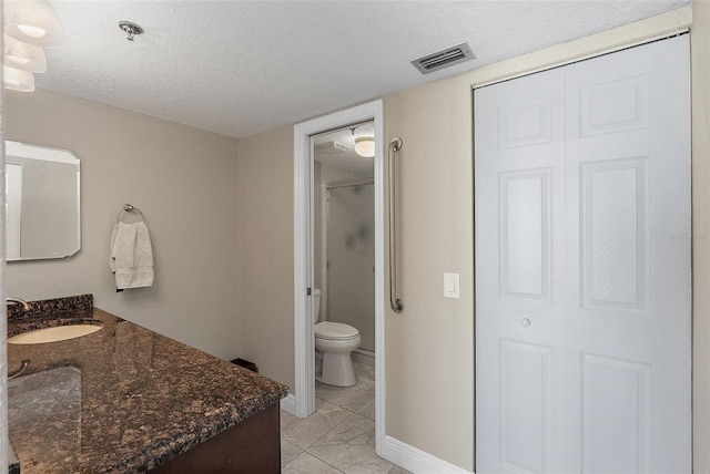 bathroom featuring vanity, an enclosed shower, a textured ceiling, and toilet