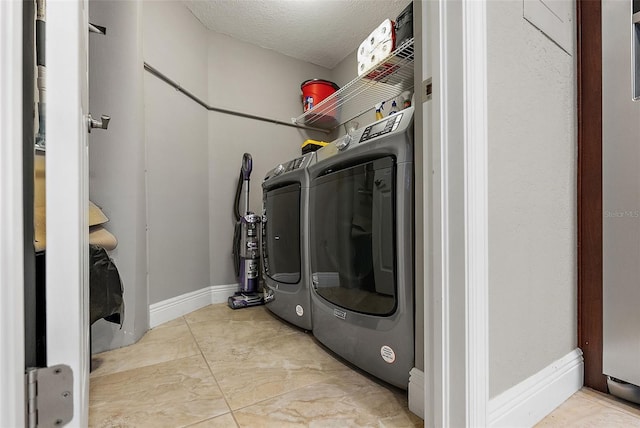 laundry area featuring washer and clothes dryer and a textured ceiling