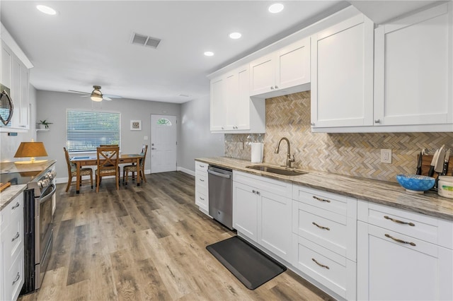 kitchen featuring sink, tasteful backsplash, appliances with stainless steel finishes, light stone countertops, and white cabinets