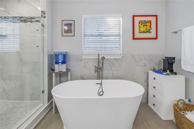 bathroom with tile walls and separate shower and tub