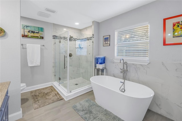 full bathroom with vanity, toilet, independent shower and bath, and tile walls