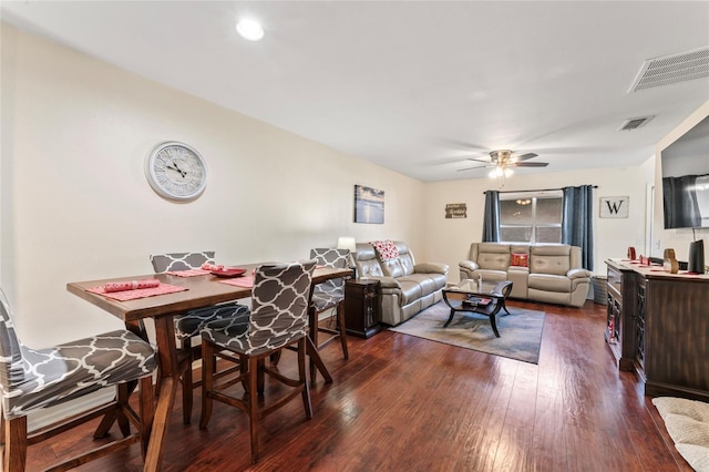 living room featuring dark wood-type flooring and ceiling fan