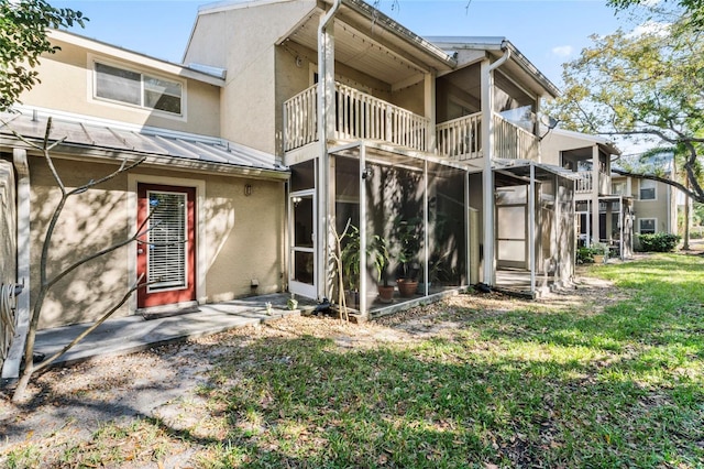 back of house with a balcony and a lawn