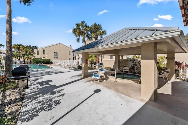 view of patio / terrace featuring a swimming pool with hot tub and a gazebo