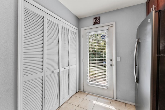 doorway to outside featuring light tile patterned flooring