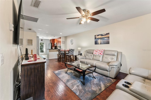 living room featuring ceiling fan and dark hardwood / wood-style flooring