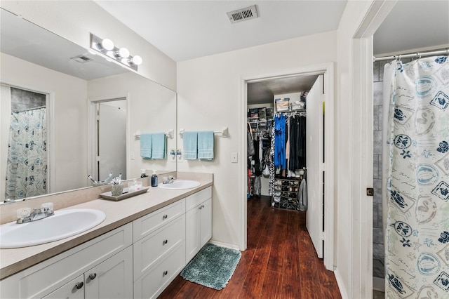 bathroom featuring walk in shower, vanity, and hardwood / wood-style floors