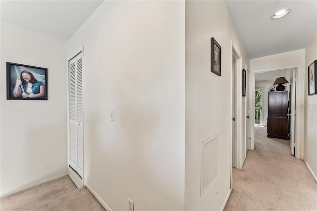 hallway featuring light colored carpet