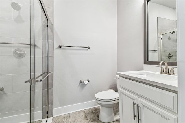 bathroom featuring a shower with door, vanity, and toilet