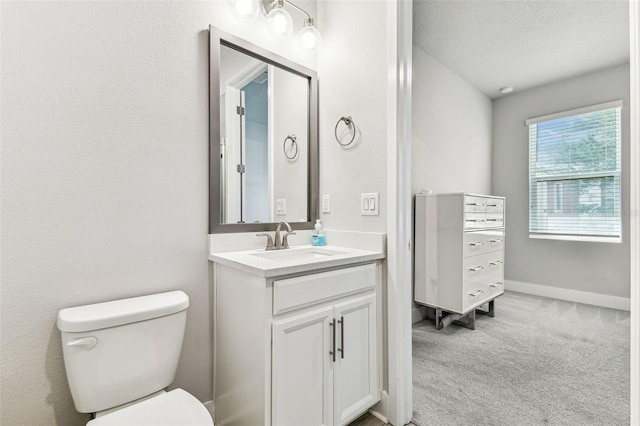 bathroom featuring vanity, a textured ceiling, and toilet