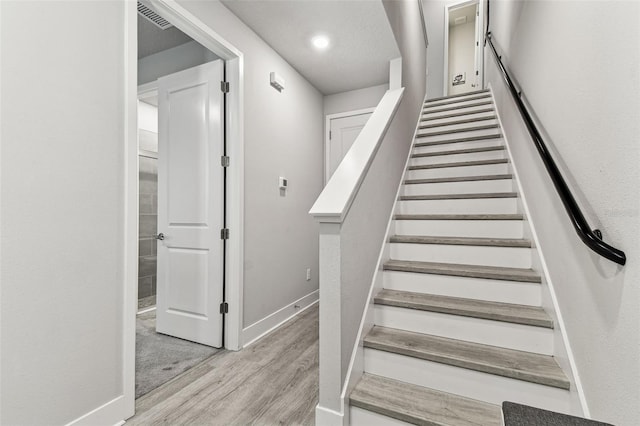 stairs with hardwood / wood-style flooring