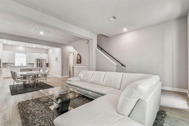 living room with sink and light hardwood / wood-style floors