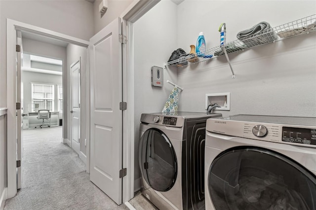 clothes washing area with light colored carpet and washer and clothes dryer