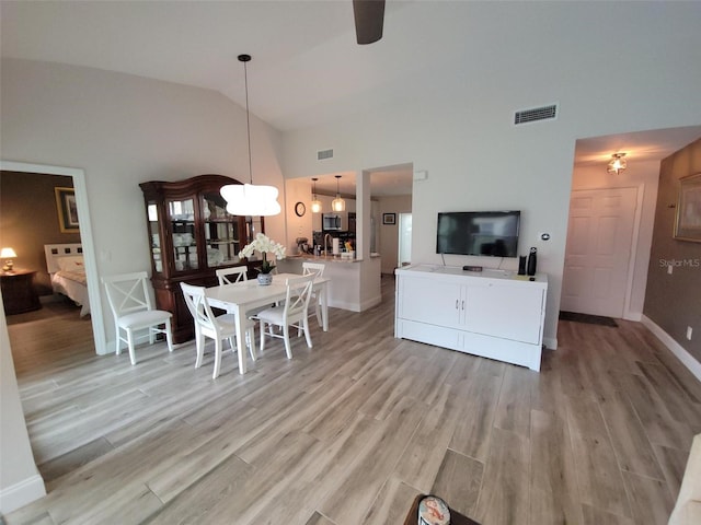 interior space featuring ceiling fan, high vaulted ceiling, and light hardwood / wood-style flooring