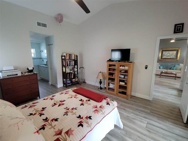 bedroom with ceiling fan, ensuite bath, lofted ceiling, and hardwood / wood-style floors