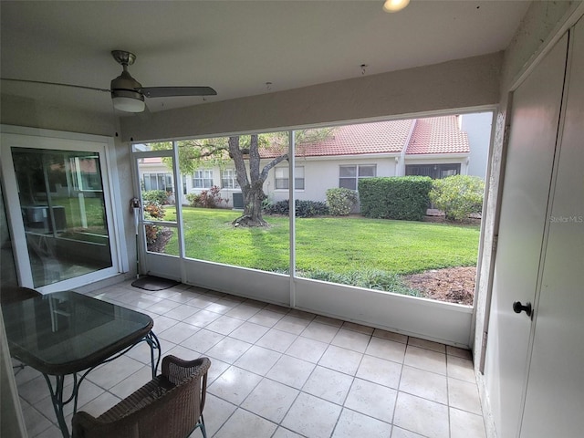 unfurnished sunroom with ceiling fan