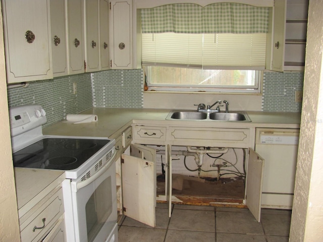 kitchen with tasteful backsplash, sink, light tile patterned floors, and white appliances