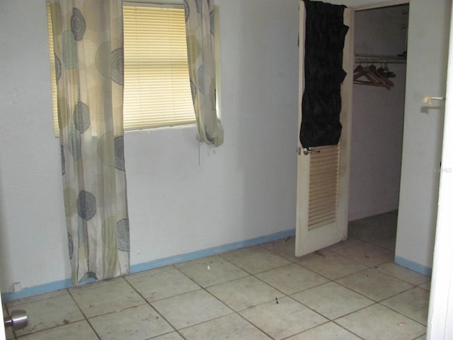 unfurnished bedroom with a closet and light tile patterned floors