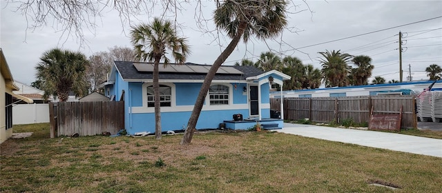 view of front of home with a front lawn and solar panels