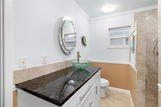 bathroom with crown molding, toilet, vanity, tile patterned flooring, and baseboards