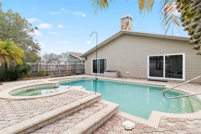 view of swimming pool featuring a fenced in pool, a patio area, fence, and an in ground hot tub