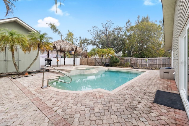 view of swimming pool featuring a pool with connected hot tub, a fenced backyard, and a patio