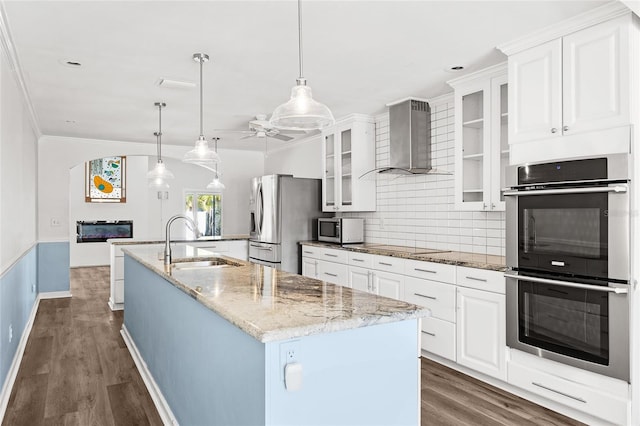 210 Lee St, Oldsmar, FL 34677 - kitchen featuring a center island with sink, a sink, stainless steel appliances, wall chimney range hood, and ceiling fan
