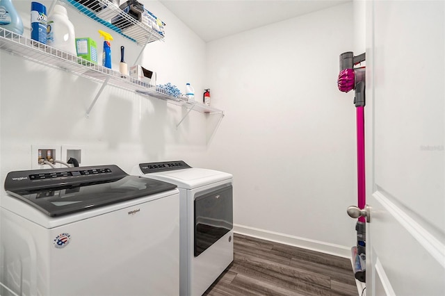 clothes washing area featuring dark wood-type flooring and washer and clothes dryer