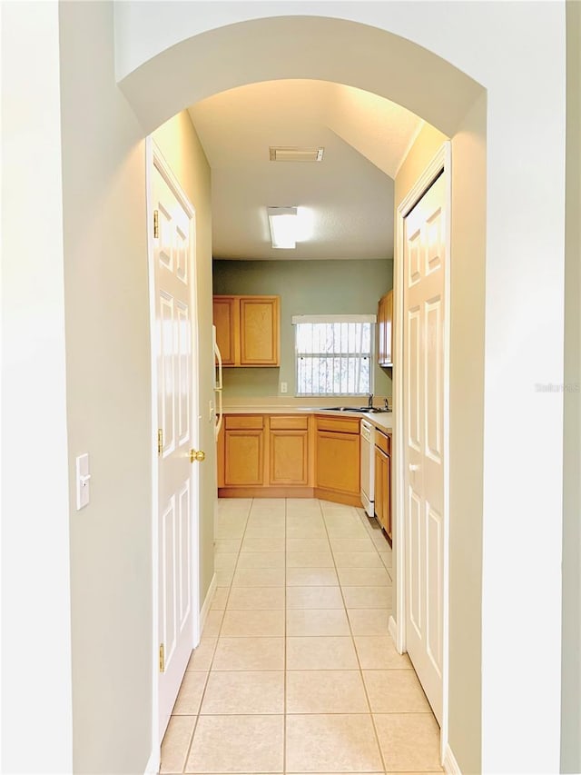 kitchen featuring light tile patterned floors, sink, dishwasher, and light brown cabinets