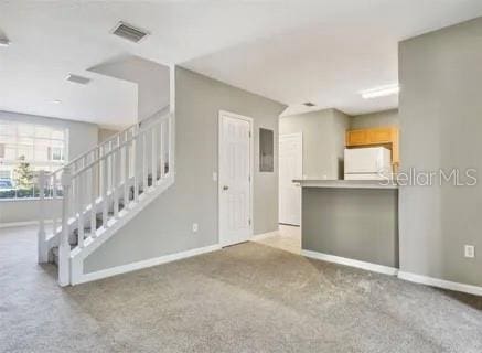 unfurnished living room featuring light carpet