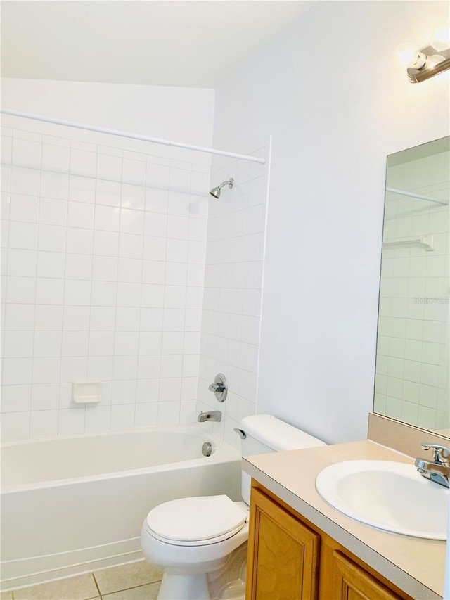 full bathroom featuring vanity, tiled shower / bath combo, tile patterned floors, and toilet