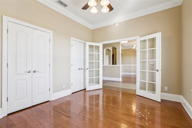 spare room featuring ornamental molding, hardwood / wood-style floors, ceiling fan, and french doors