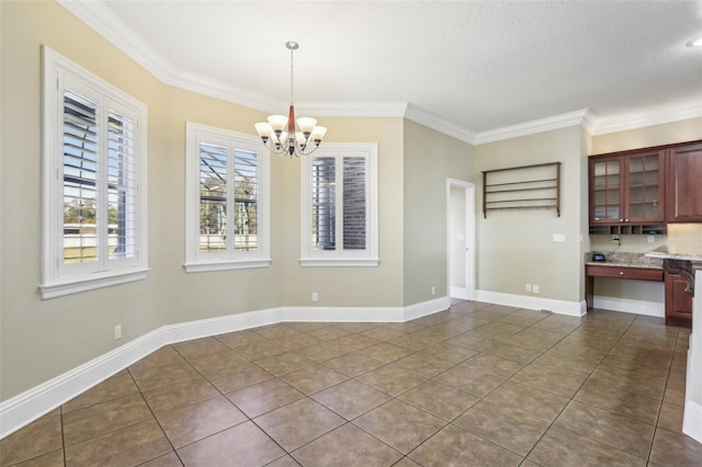 unfurnished dining area with ornamental molding, a chandelier, and dark tile patterned floors