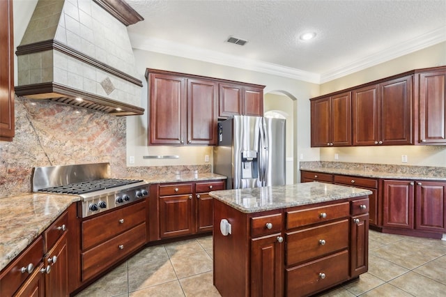 kitchen featuring light tile patterned floors, appliances with stainless steel finishes, a center island, light stone countertops, and custom range hood