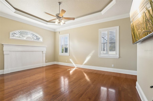 unfurnished living room with ceiling fan, a tray ceiling, a textured ceiling, and hardwood / wood-style flooring